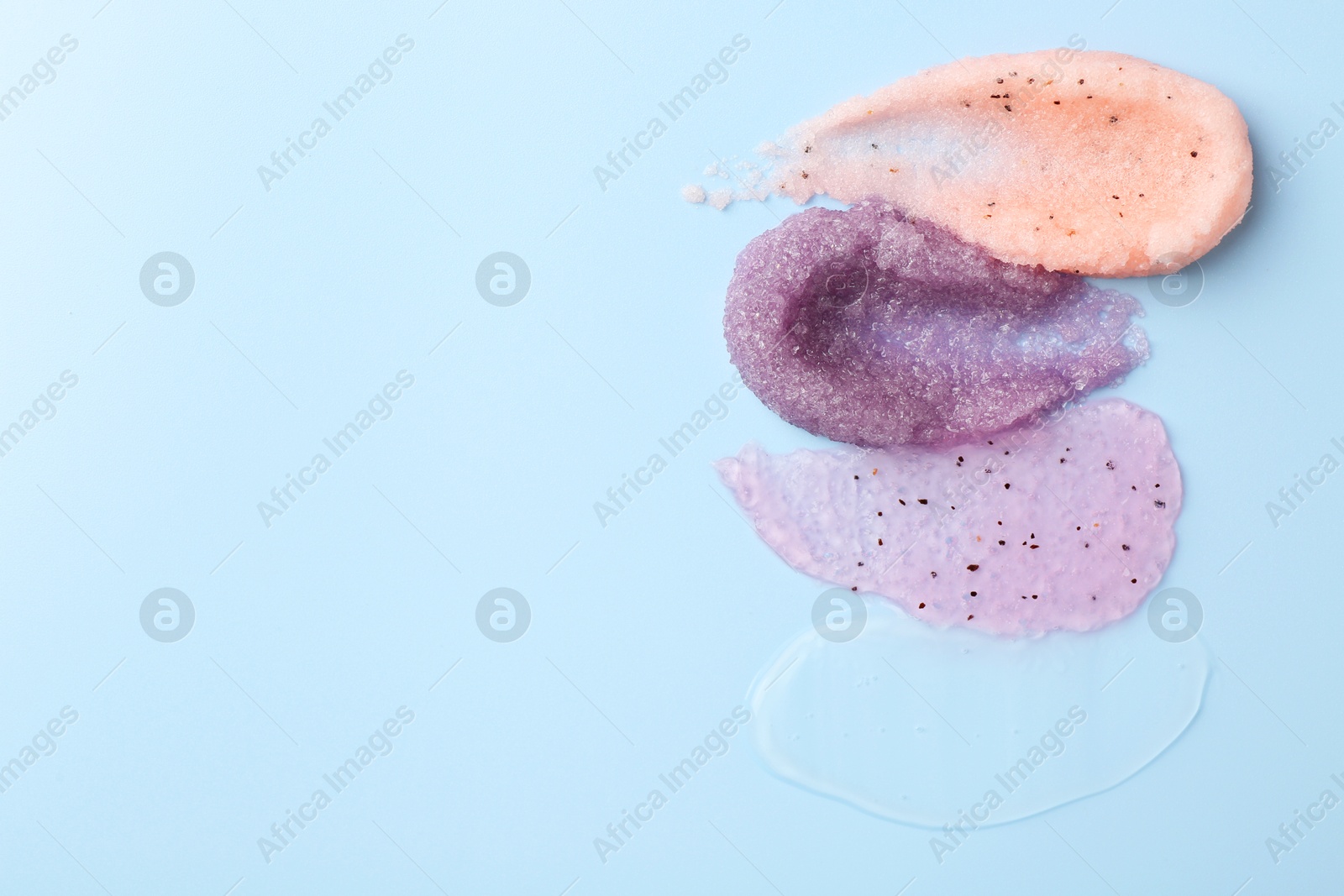 Photo of Samples of cosmetic products on light blue background, top view. Space for text. Skin care