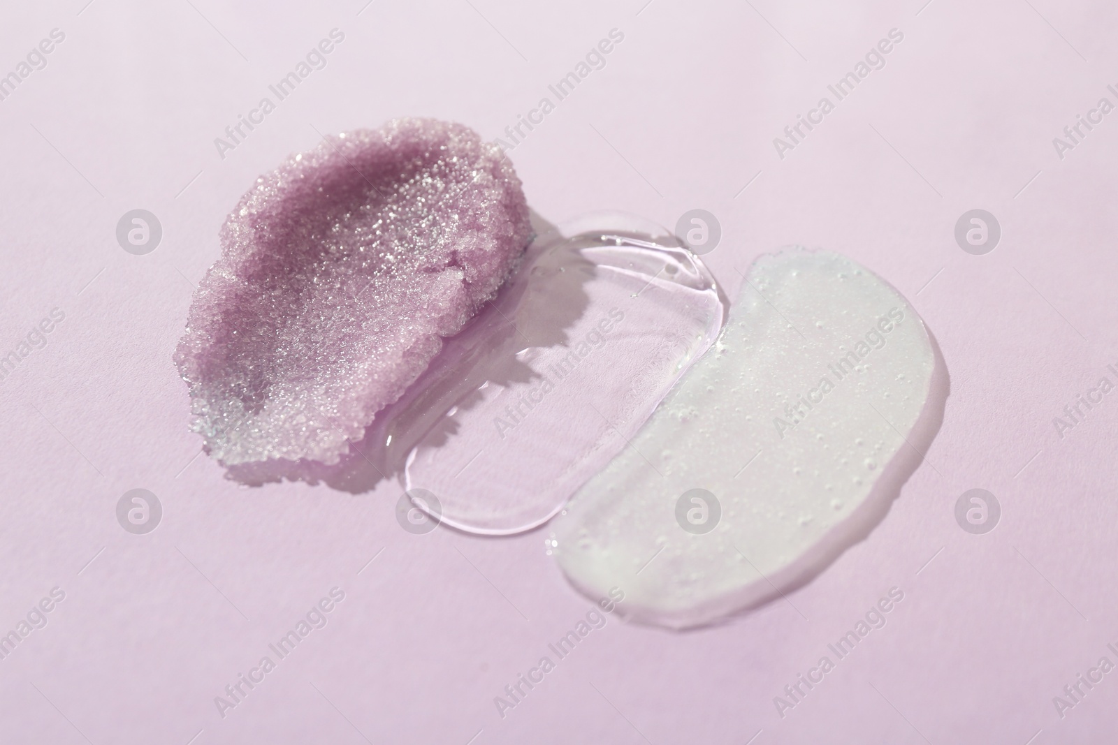 Photo of Samples of cosmetic products on light violet background, closeup. Skin care