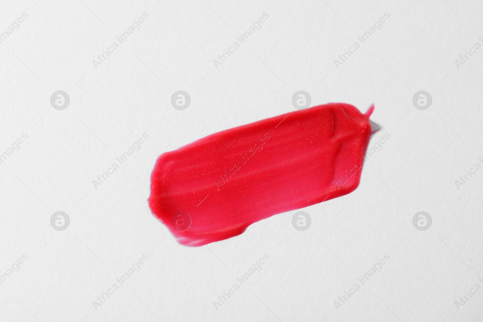 Photo of Sample of red lipgloss on light grey background, top view