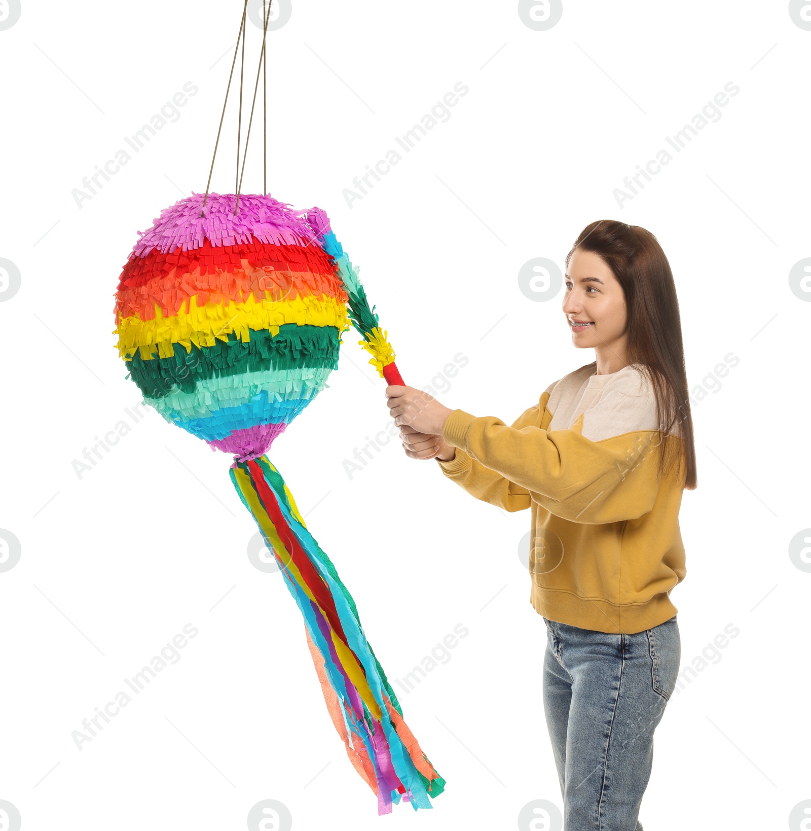 Photo of Happy woman hitting colorful pinata with stick on white background