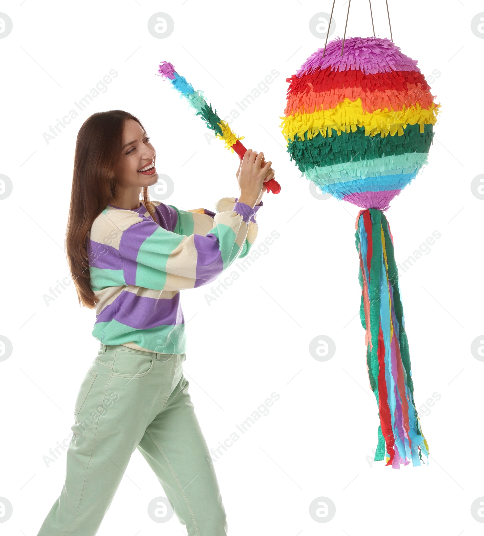 Photo of Happy woman breaking colorful pinata with stick on white background