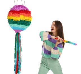 Photo of Happy woman breaking colorful pinata with stick on white background