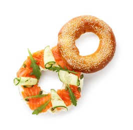 Photo of Delicious bagel with salmon, cream cheese and cucumber isolated on white, top view