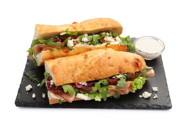 Photo of Halves of baguette sandwich with prosciutto and sun dried tomatoes isolated on white