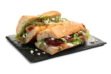 Photo of Halves of baguette sandwich with prosciutto and sun dried tomatoes isolated on white