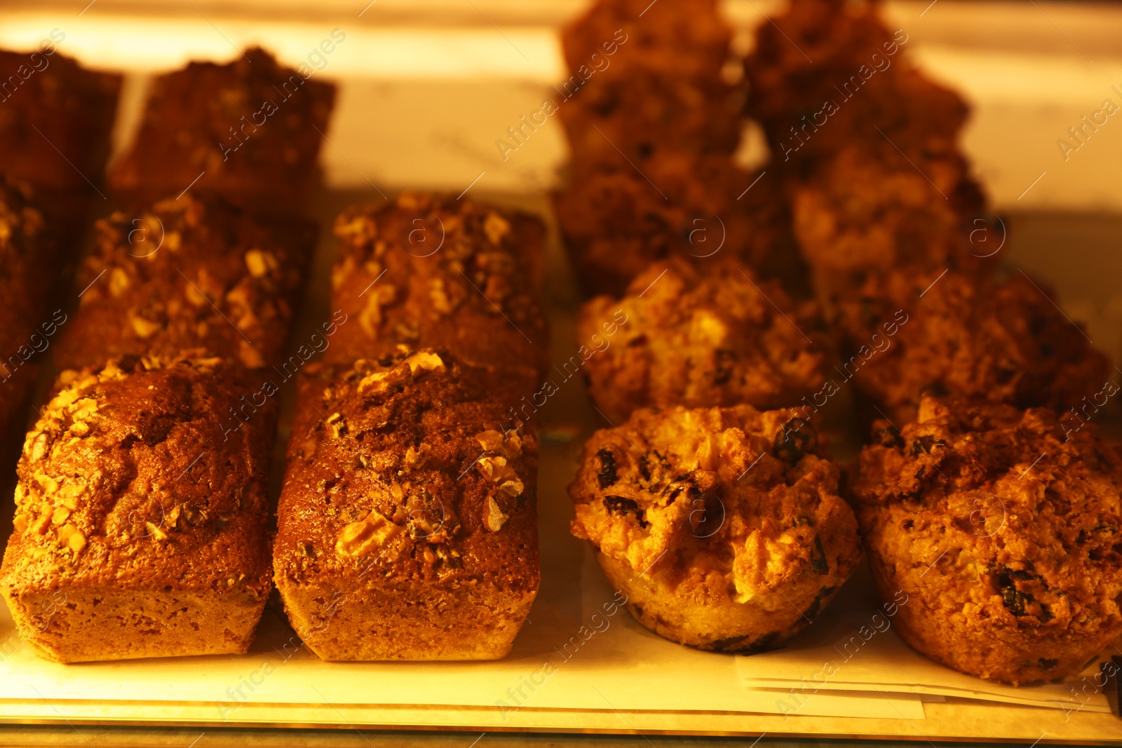 Photo of Delicious sweet pastries on display in cafe, closeup