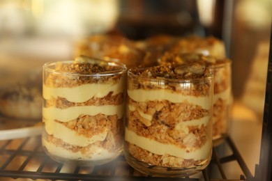 Photo of Delicious desserts in glasses on display at cafe, closeup