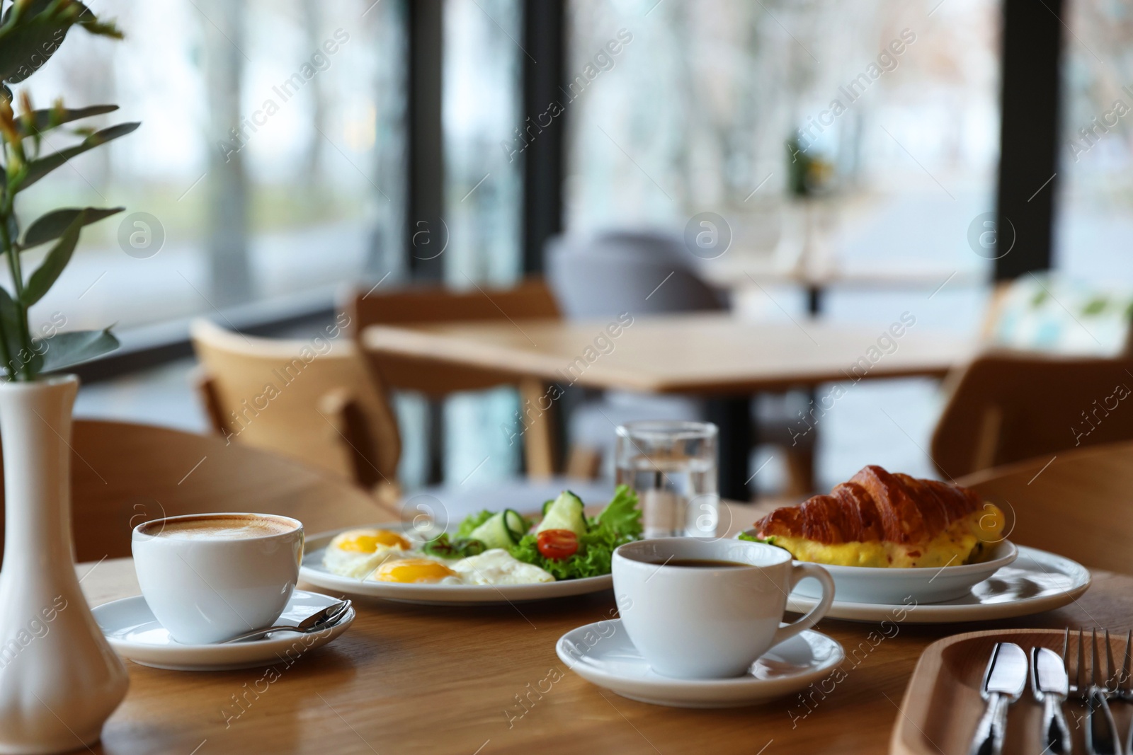 Photo of Delicious breakfast served on wooden table in cafe