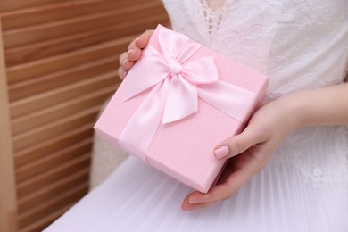 Photo of Bride with beautiful wedding gift indoors, closeup. Space for text