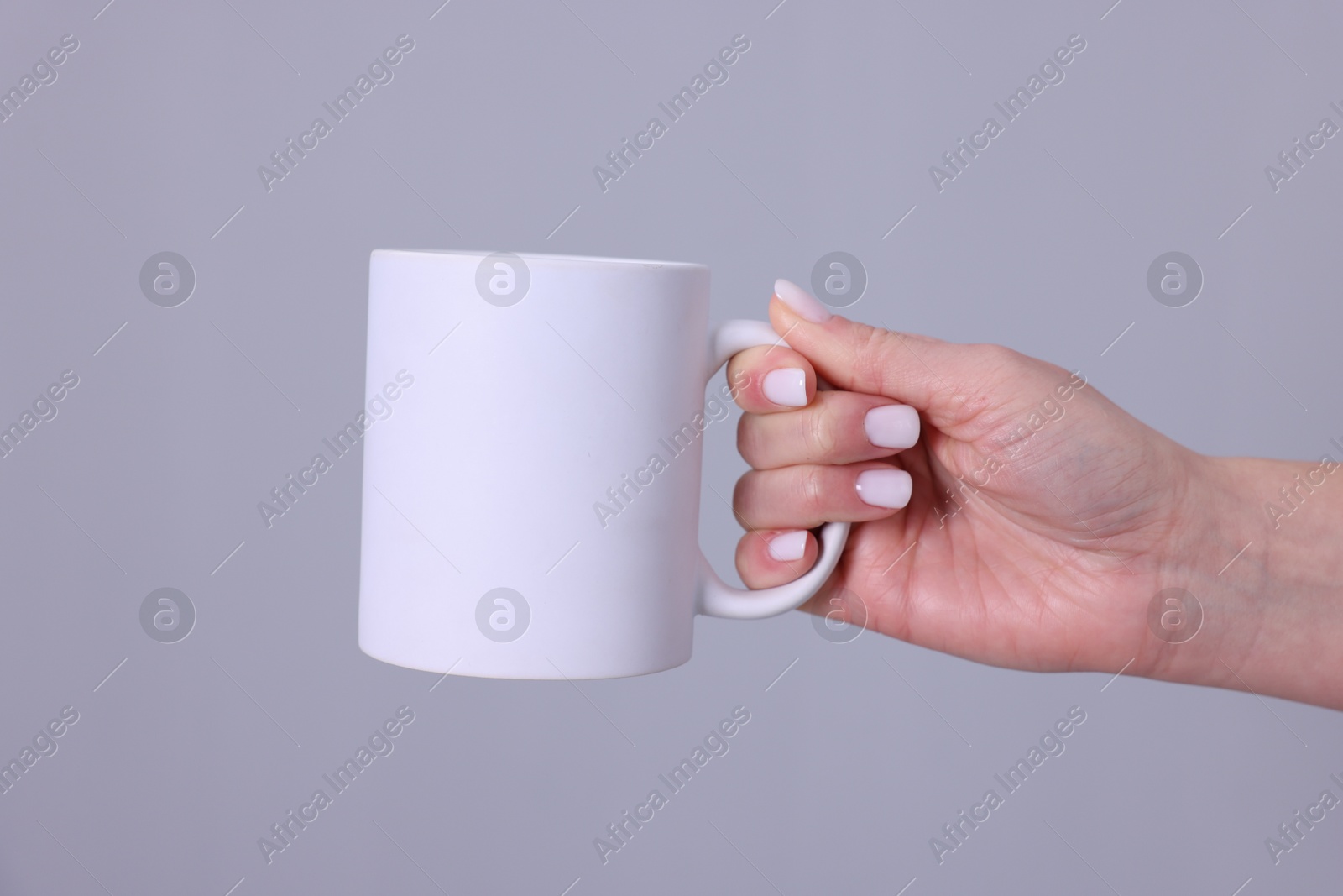 Photo of Woman with blank white cup on grey background, closeup. Mockup for design