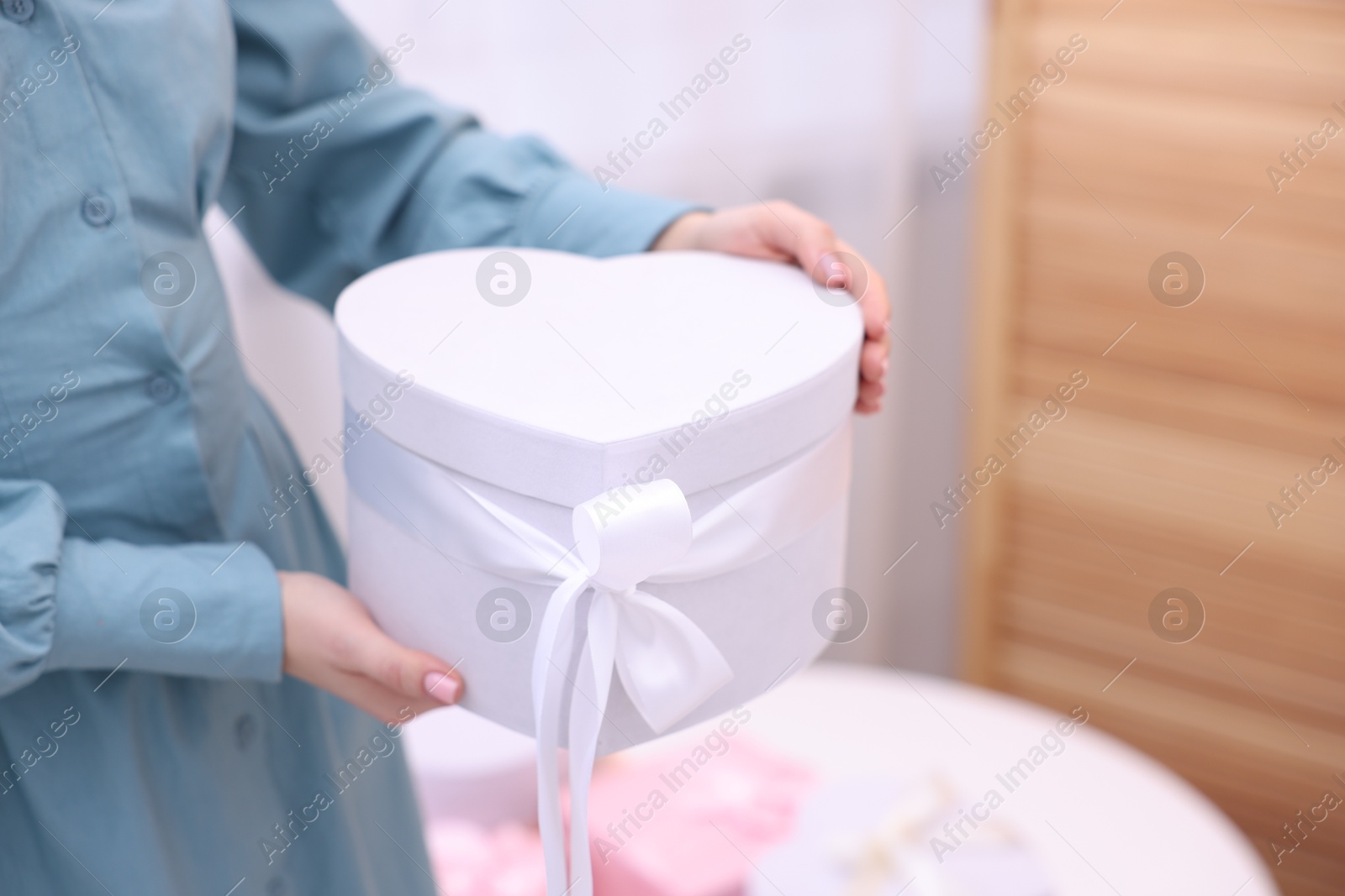 Photo of Woman with beautiful wedding gift indoors, closeup. Space for text