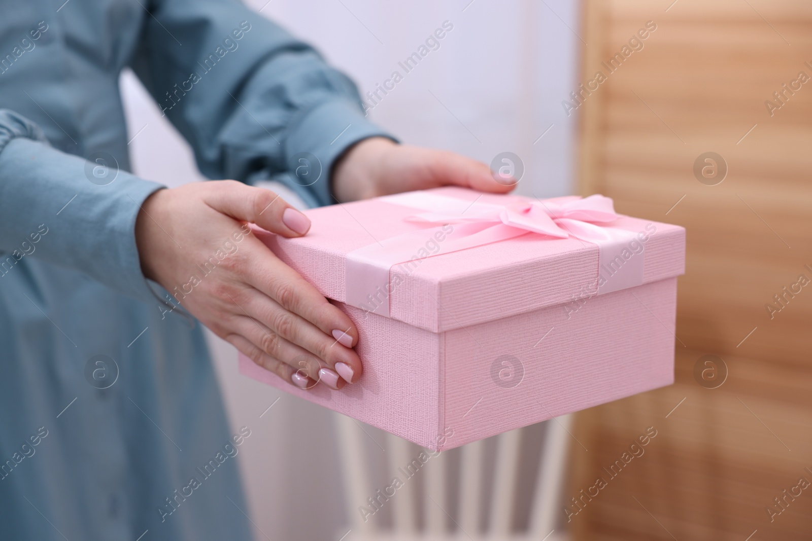 Photo of Woman with beautiful wedding gift indoors, closeup