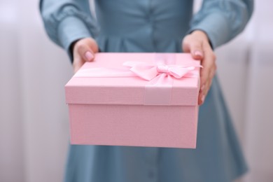 Photo of Woman with beautiful wedding gift indoors, closeup