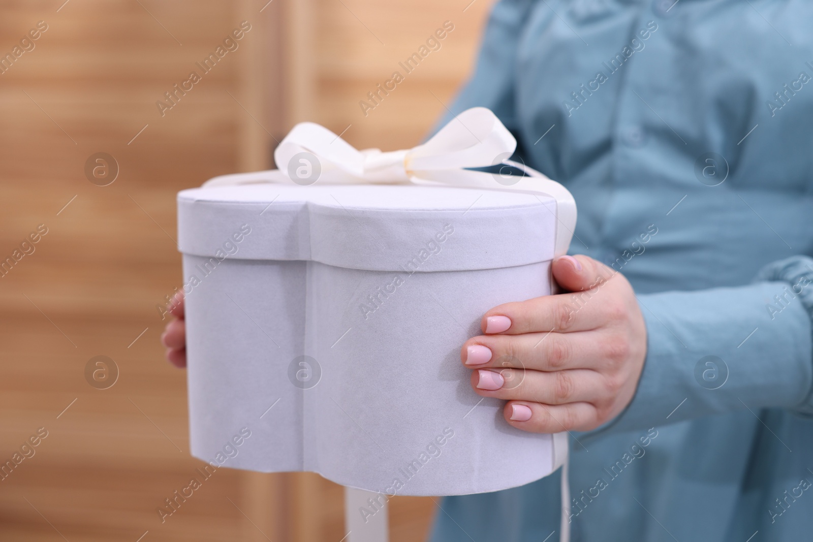 Photo of Woman with beautiful wedding gift indoors, closeup