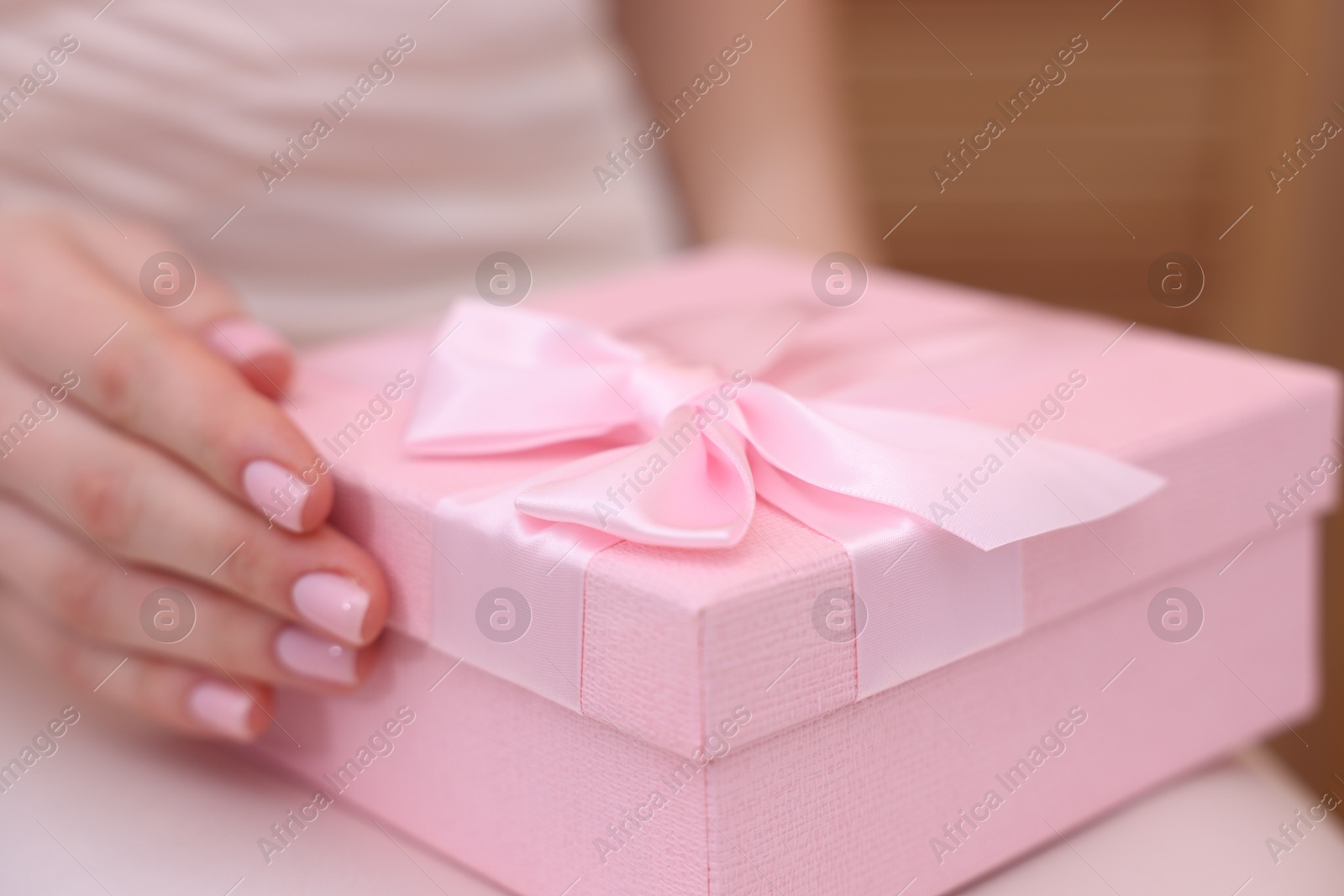 Photo of Bride with beautiful wedding gift indoors, closeup