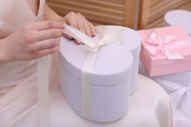 Bride opening beautiful wedding gift indoors, closeup