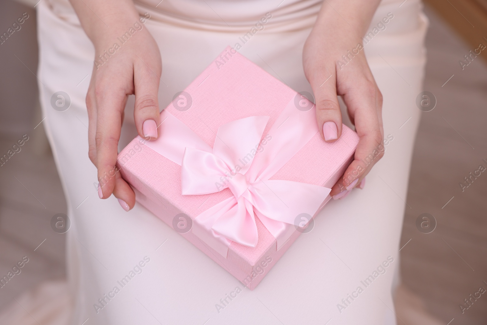 Photo of Bride with beautiful wedding gift indoors, above view