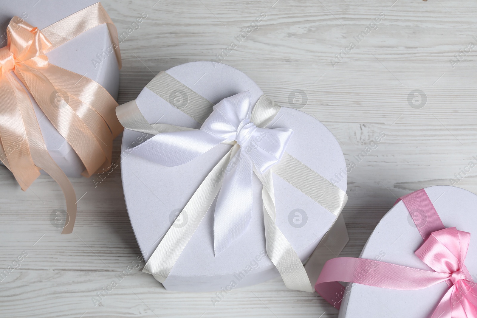 Photo of Beautiful wedding gifts on light wooden table, flat lay