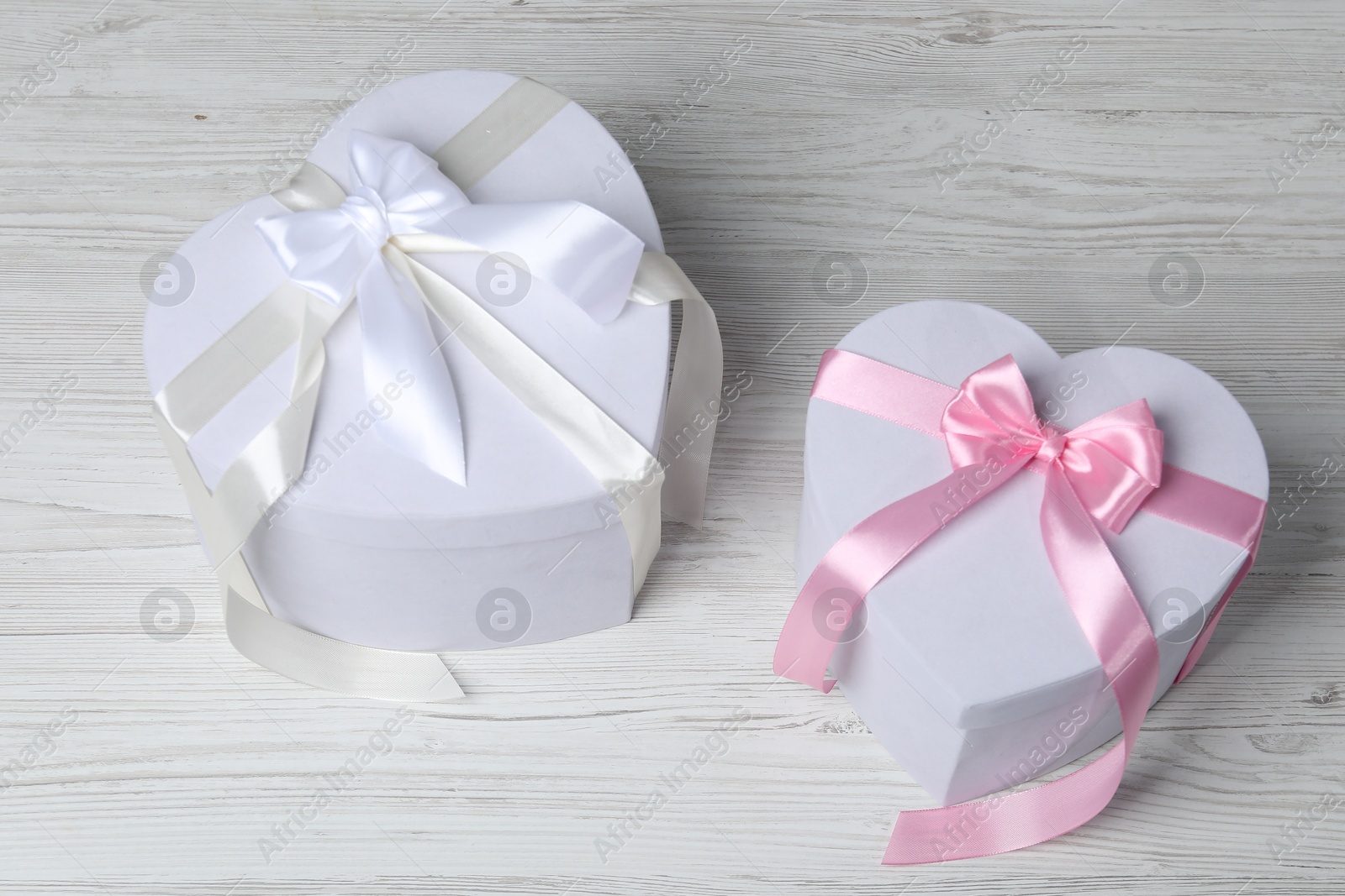 Photo of Beautiful wedding gifts on light wooden table, above view