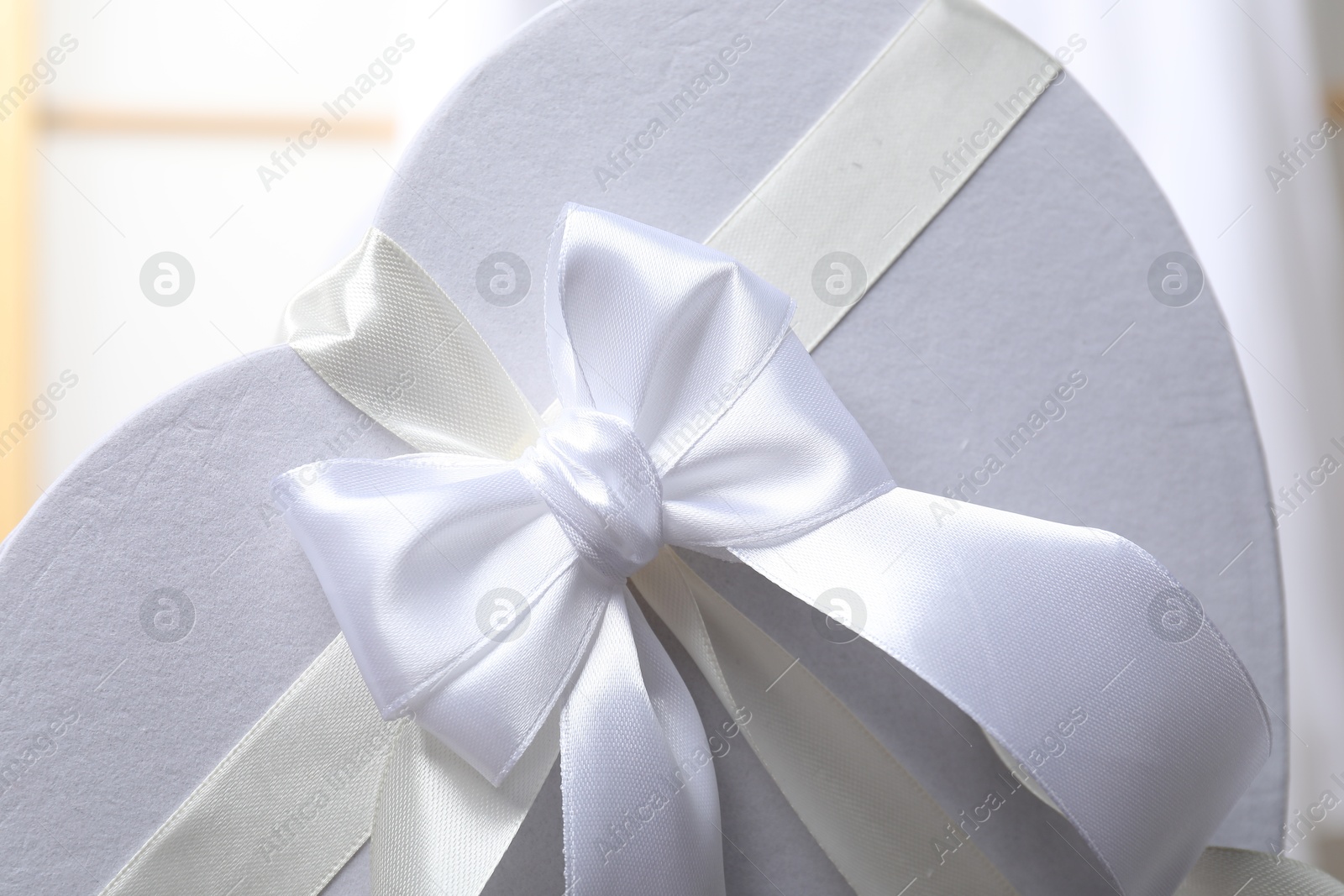 Photo of Beautiful wedding gift on blurred background, closeup