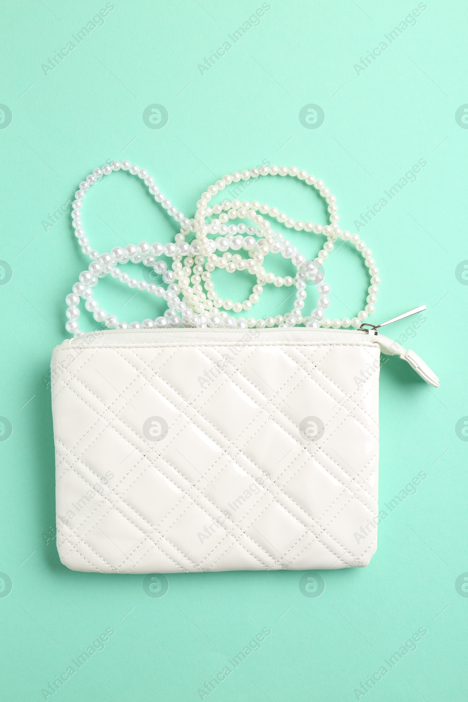 Photo of Beautiful bag and stylish accessories on turquoise background, flat lay