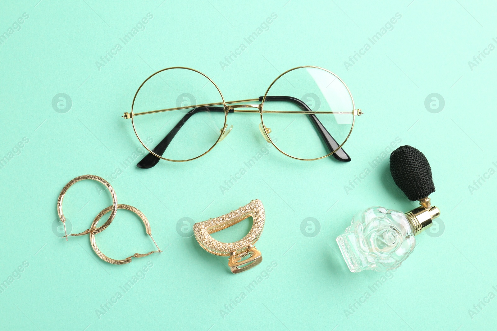 Photo of Stylish accessories and perfume on turquoise background, flat lay