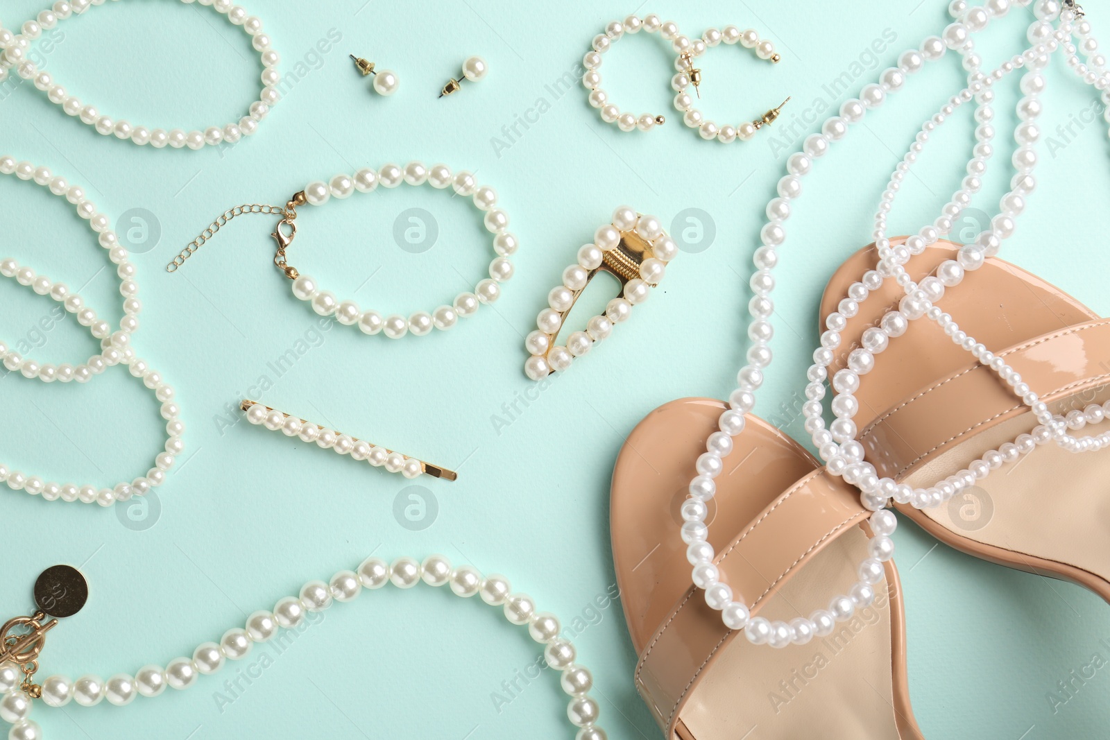 Photo of Stylish accessories and shoes on light blue background, flat lay