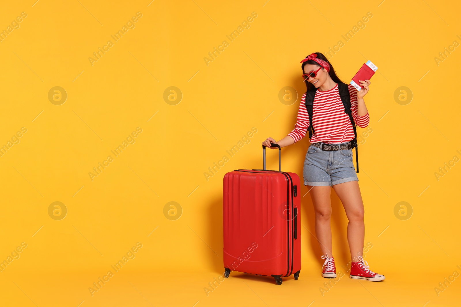 Photo of Traveller with passport and suitcase on yellow background. Space for text