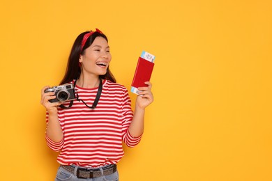 Photo of Happy traveller with passport and camera on yellow background. Space for text