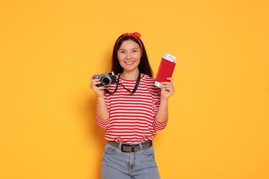 Photo of Happy traveller with passport and camera on yellow background