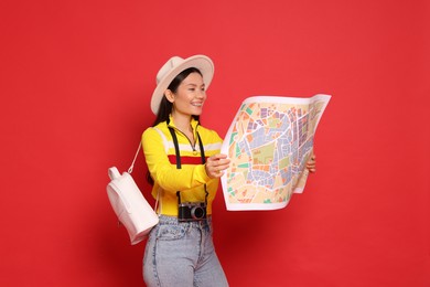 Photo of Happy traveller with map on red background