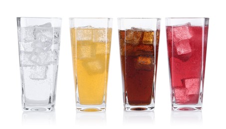 Photo of Soda water of different flavors with ice cubes in glasses isolated on white