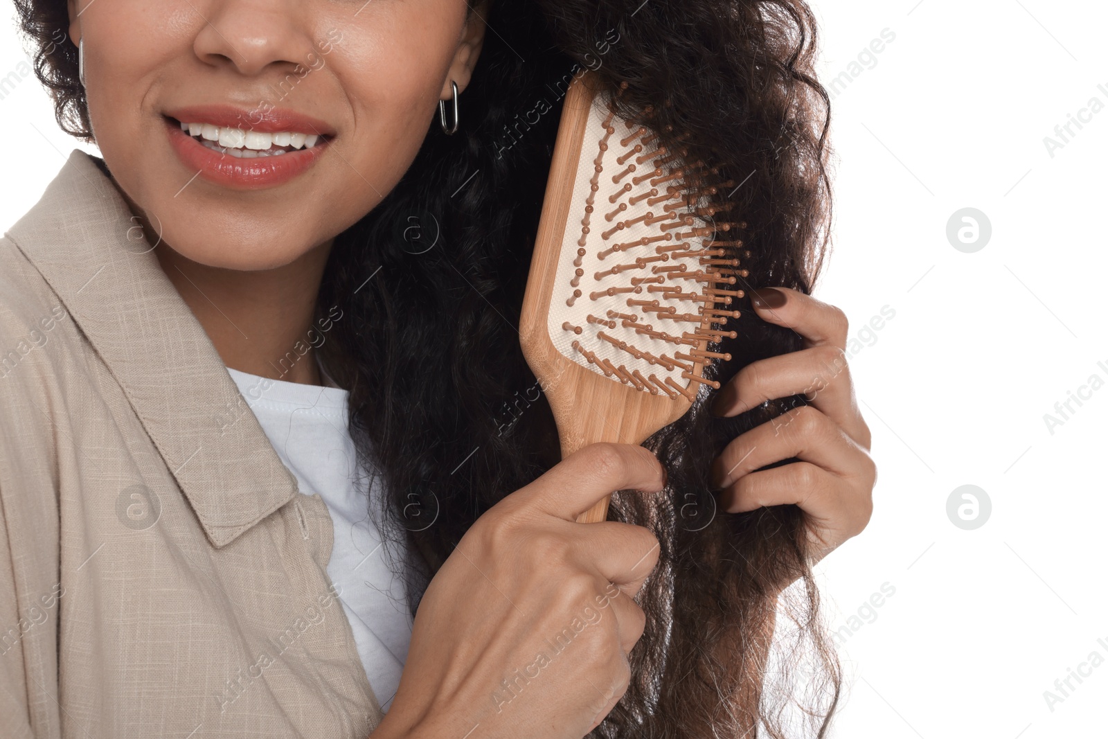 Photo of Woman brushing her curly hair on white background, closeup