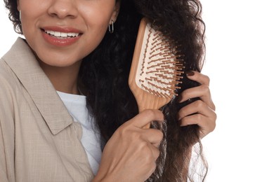 Photo of Woman brushing her curly hair on white background, closeup