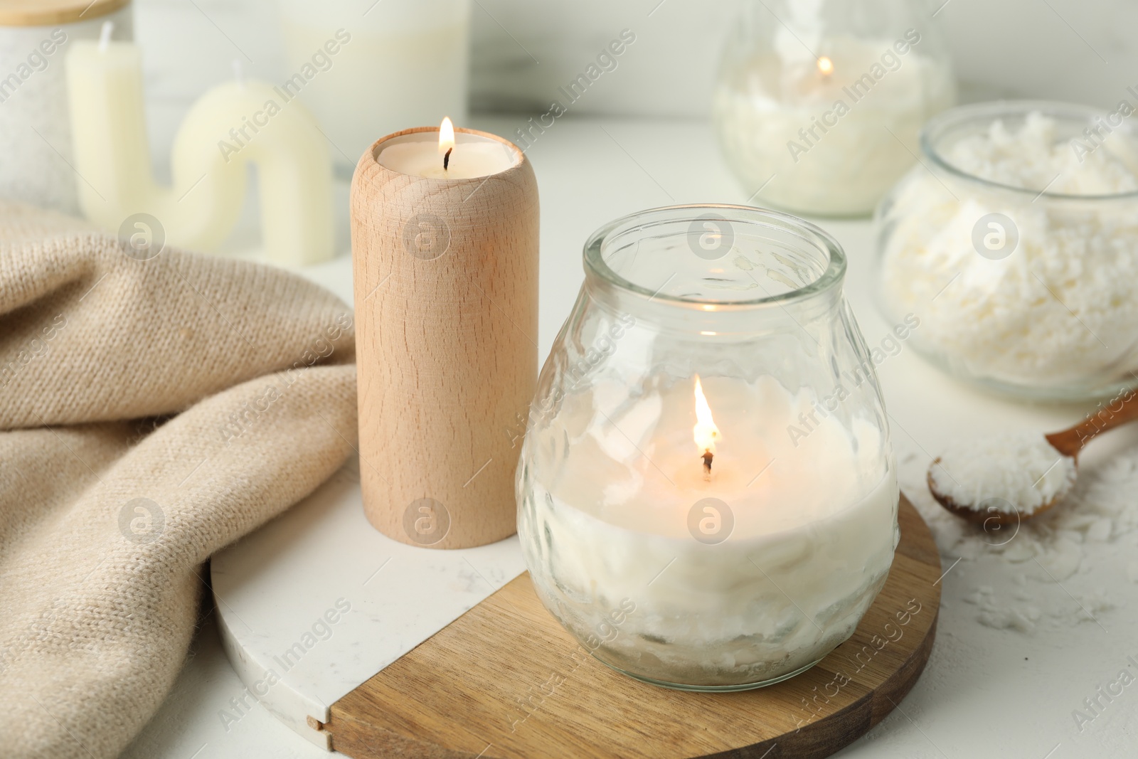 Photo of Burning soy wax candles on light table, closeup