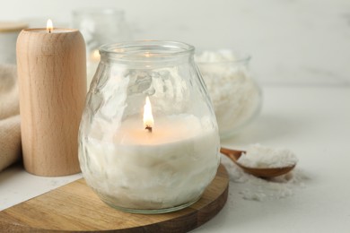 Photo of Burning soy wax candles on light table, closeup. Space for text