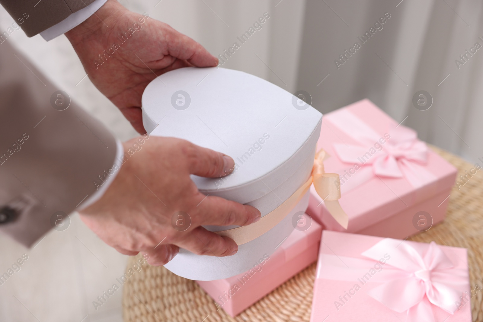 Photo of Groom with beautiful wedding gifts indoors, closeup