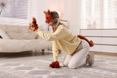 Photo of Quadrobics. Woman wearing fox mask, gloves and tail at home