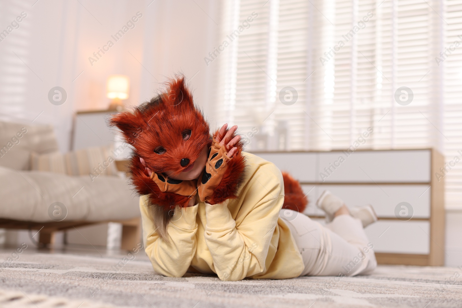 Photo of Quadrobics. Woman wearing fox mask and gloves at home