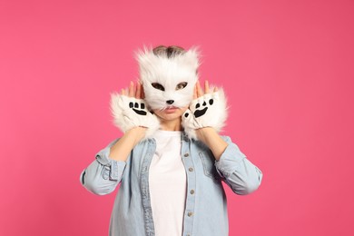 Photo of Quadrobics. Woman wearing cat mask and gloves on pink background