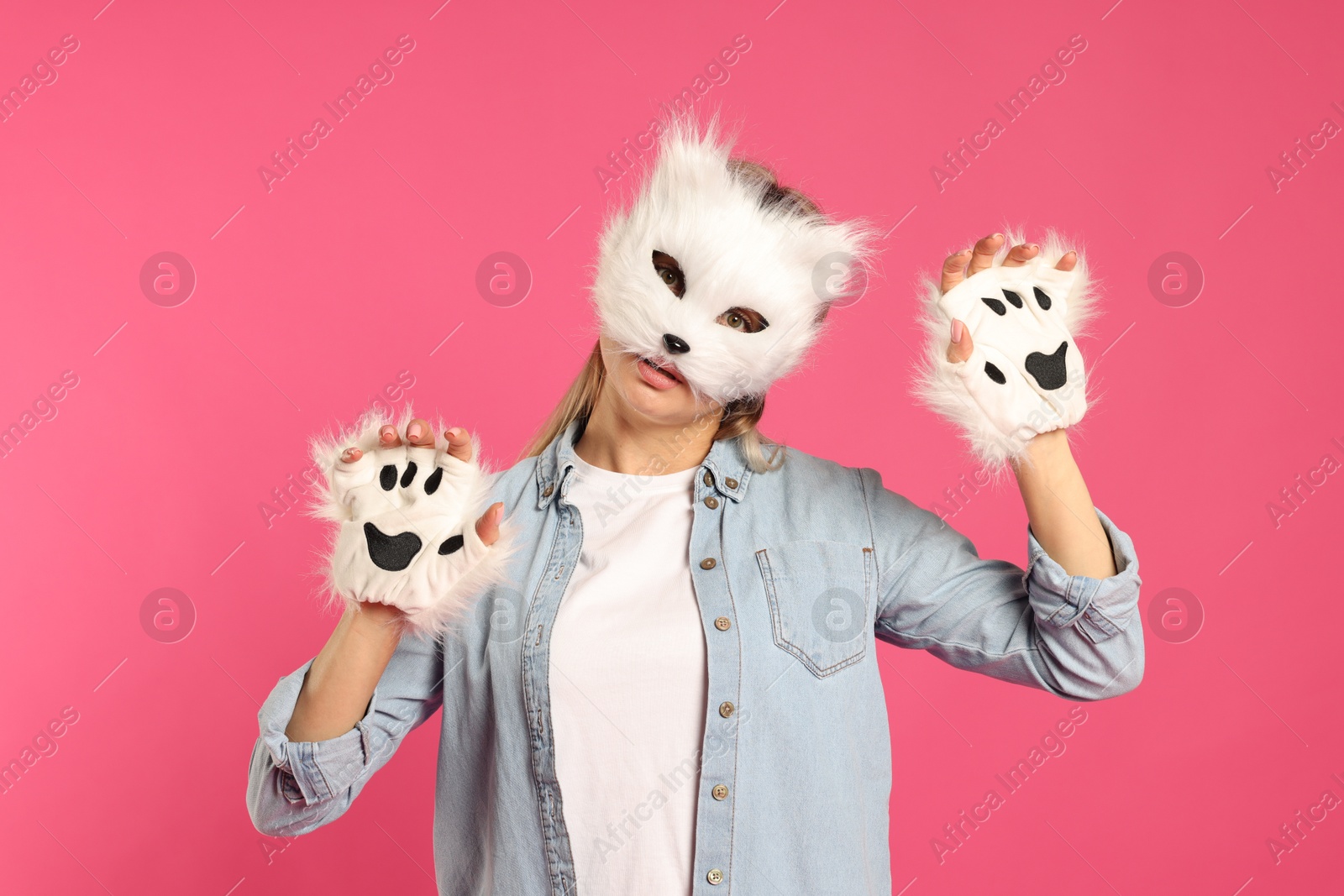 Photo of Quadrobics. Woman wearing cat mask and gloves on pink background