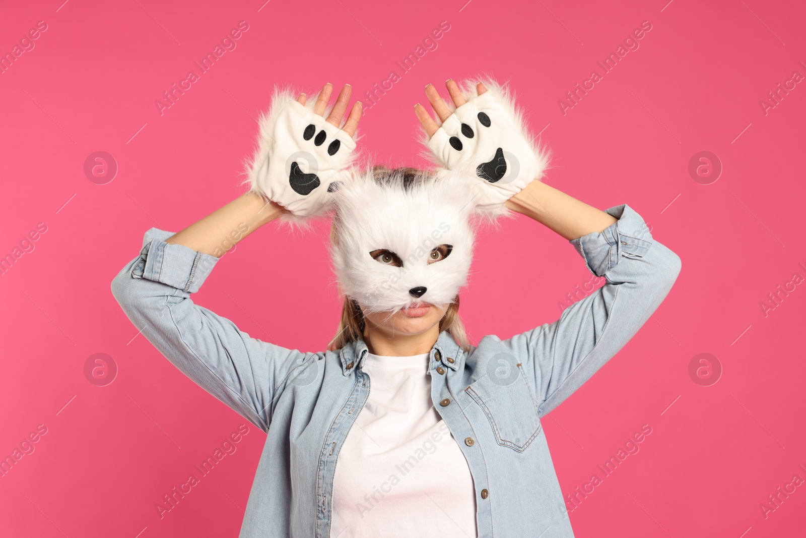 Photo of Quadrobics. Woman wearing cat mask and gloves on pink background