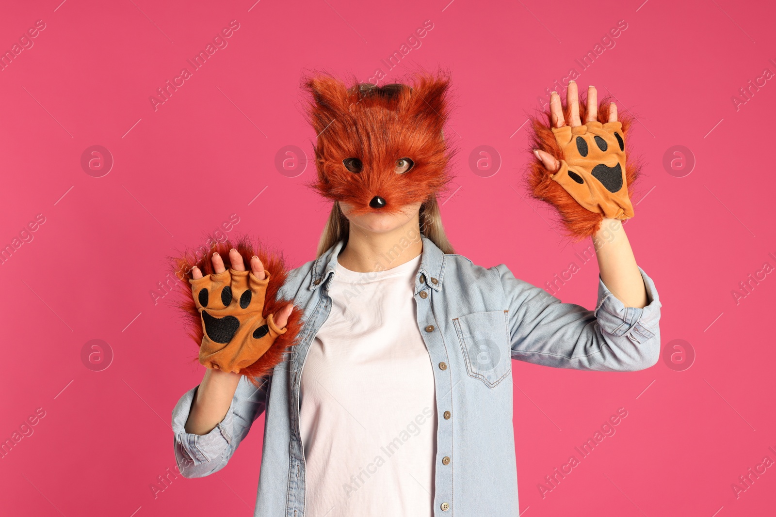 Photo of Quadrobics. Woman wearing fox mask and gloves on pink background