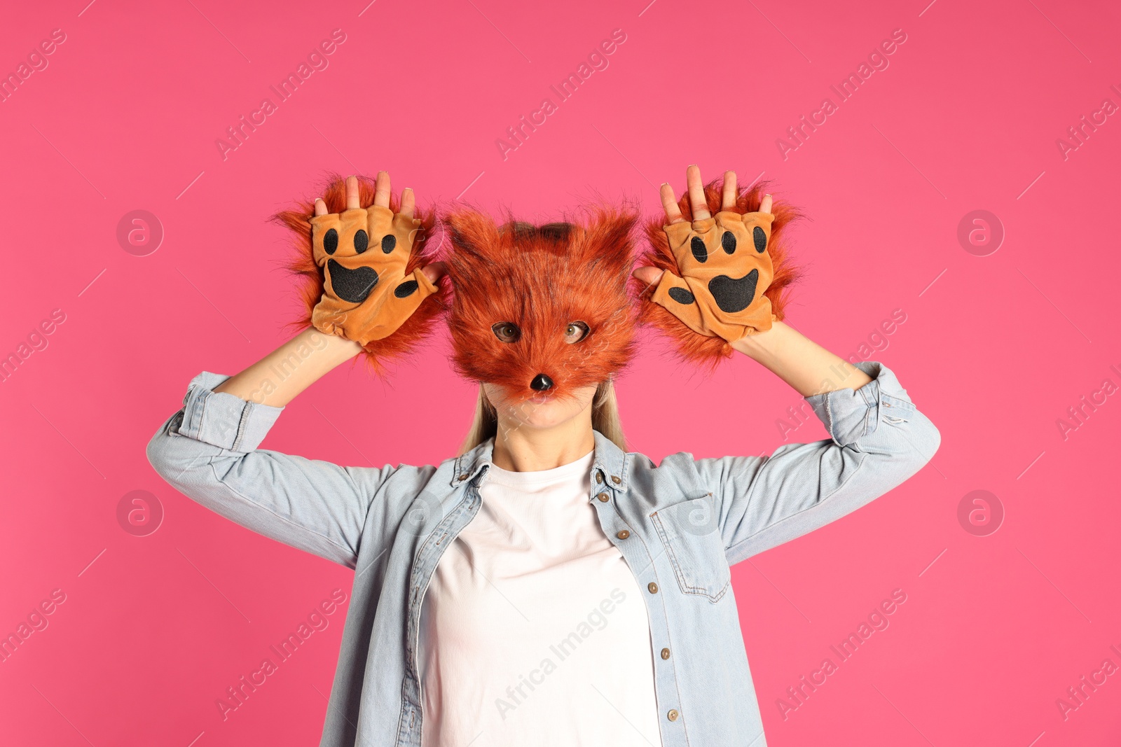 Photo of Quadrobics. Woman wearing fox mask and gloves on pink background