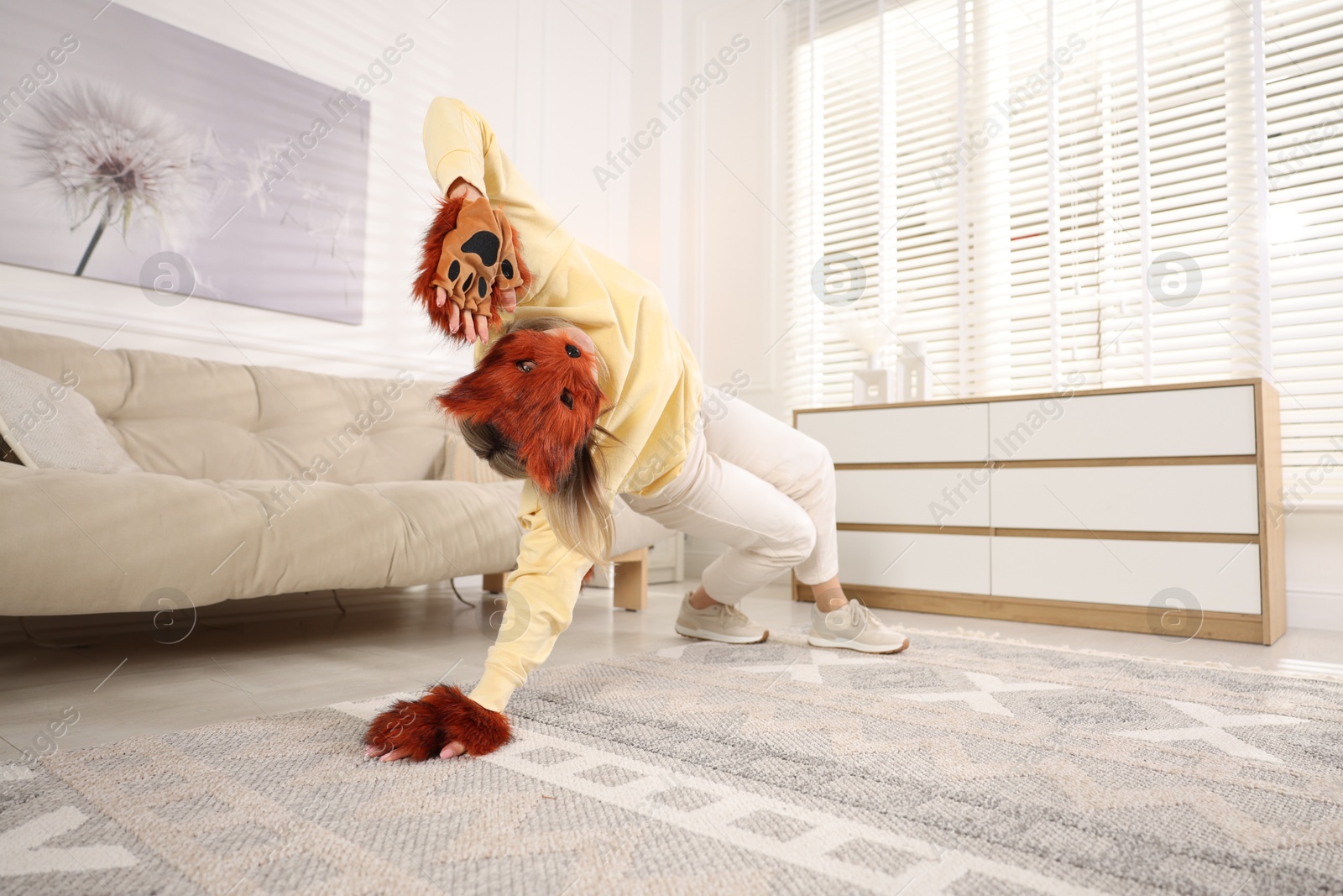 Photo of Quadrobics. Woman wearing fox mask and gloves at home