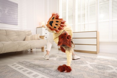 Photo of Quadrobics. Woman wearing fox mask, gloves and tail at home