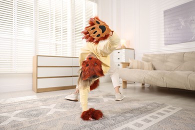 Photo of Quadrobics. Woman wearing fox mask, gloves and tail at home