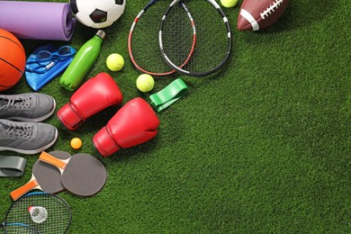 Photo of Different sport equipment on artificial grass, flat lay. Space for text