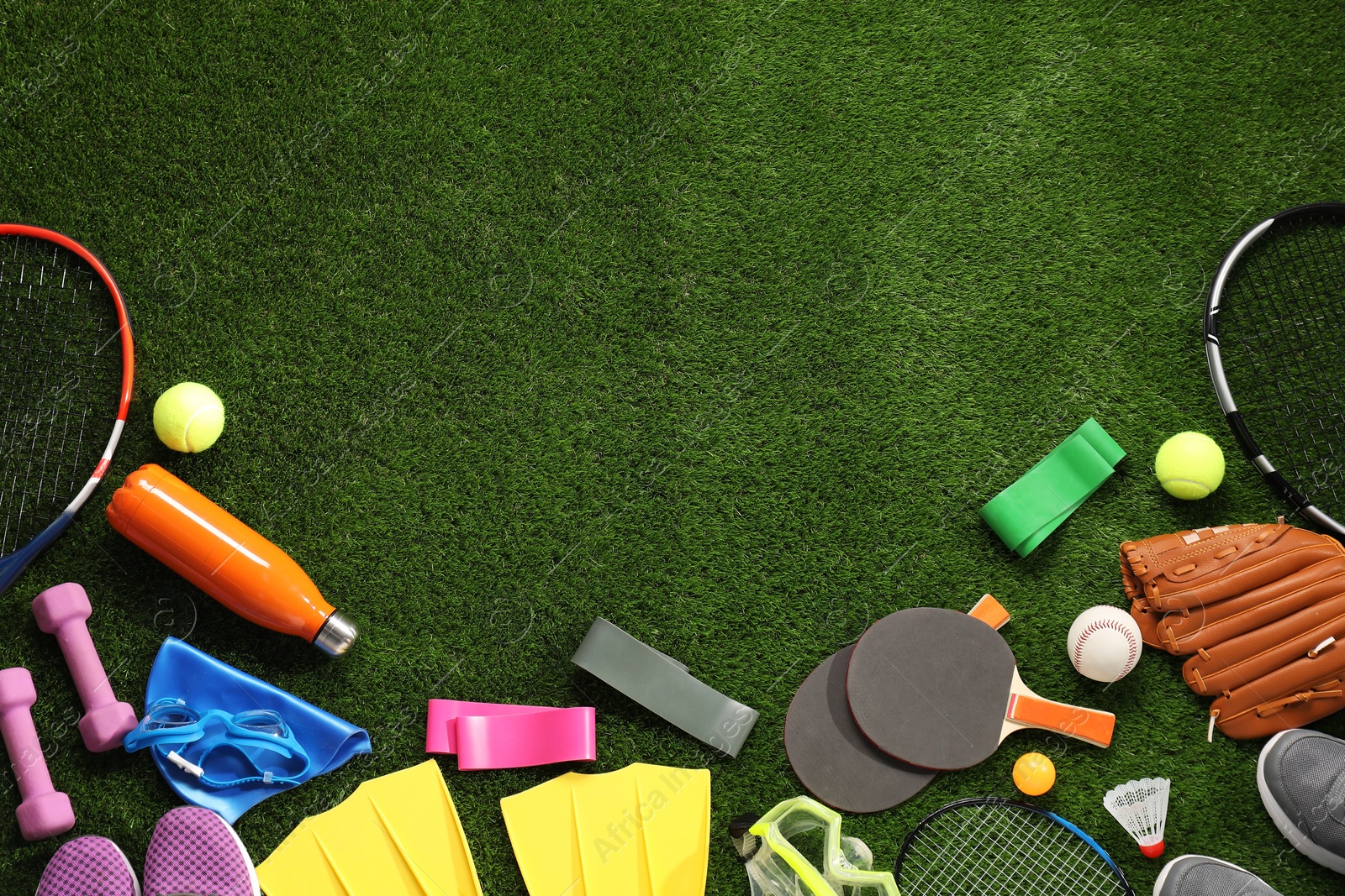 Photo of Different sport equipment on artificial grass, flat lay. Space for text