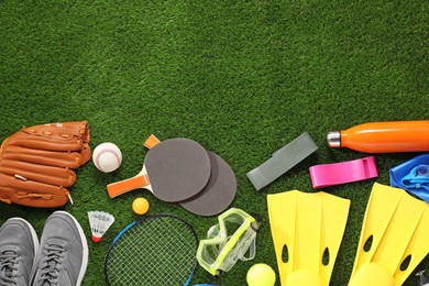 Photo of Different sport equipment on artificial grass, flat lay. Space for text